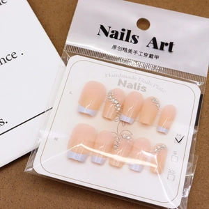 Handgefertigte French-Nägel in Nude-Rosa und Weiß mit funkelnden Strassstein-Akzenten