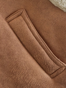 Detail of brown faux suede vest showing pocket stitching and soft faux shearling lining