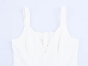 Dettaglio dello scollo a V e della cerniera frontale sull'elegante abito bianco