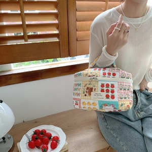 Gros plan détaillé d'une trousse de maquillage matelassée avec motifs et poignée