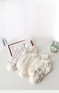 Detail of white cotton ankle socks set with assorted lace edges and floral patterns