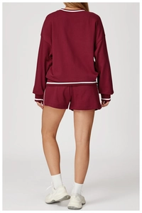 Détails du survêtement bordeaux avec rayures blanches sur le sweat-shirt et le short