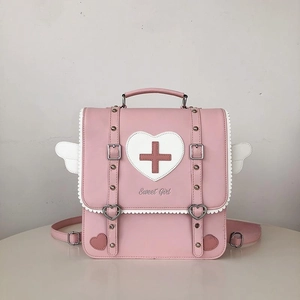 Close-up of pink heart appliqué with red cross and heart-shaped metal buckle detail