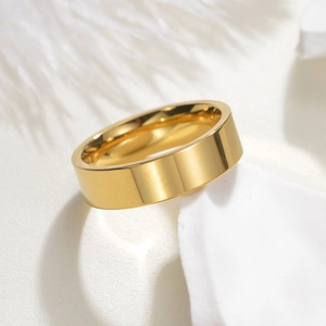 Detail view of a 8mm wide golden stainless steel ring with polished mirror finish surface