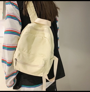 Detailansicht eines cremeweißen Segeltuch-Rucksacks am Modell zeigt Gurt und Größe