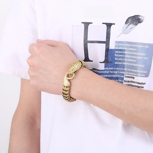 Close-up of golden snake head clasp on punk style chain bracelet for men worn on wrist