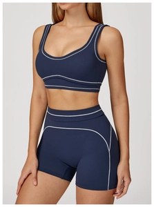 Close-up of contrast white stitching on dark blue athletic bra and gym shorts set