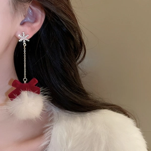 Detail of Christmas snowflake earrings with red velvet bow and white fuzzy pompom