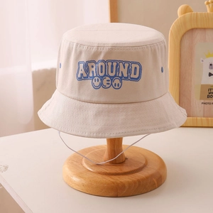 Detail of cream bucket hat with blue smile embroidery and adjustable windproof rope