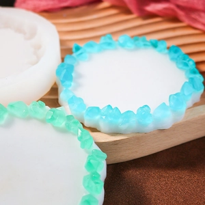 Détail du moule en silicone rond avec dessous de verre en résine et amas de cristaux colorés
