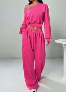 Detail von rosa schulterfreiem Sweatshirt und weitem Kordelzug-Hosenstoff in Nahaufnahme