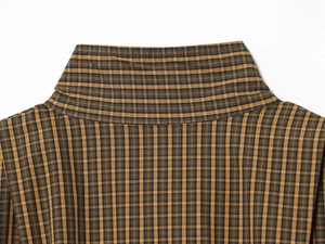 Detail of classic plaid shirt collar in brown and yellow with refined stitching