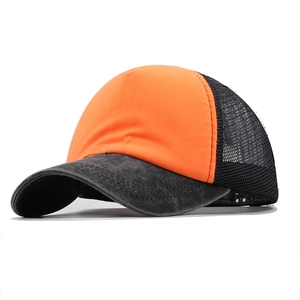 Side view of two-tone mesh trucker hat with orange front and grey washed denim brim