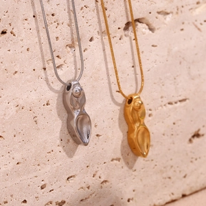 Détail de pendentifs dague en or et argent avec finition polie sur fond en pierre