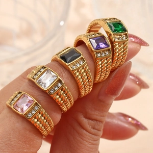 Close-up of five gold rings with rectangular zircon stones in multiple vibrant colors