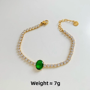 Detail of gold multilayer bracelet with emerald zircon and S.Steel weight tag