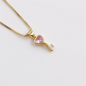 Detail of pink crystal heart key pendant on gold plated box chain for women