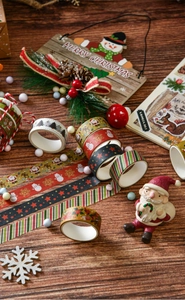 Close-up of 6 rolls Christmas washi tape set featuring Santa and pine cone decorations