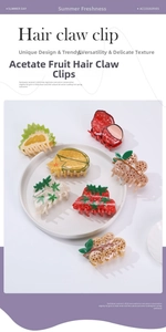 Detailed view of assorted acetate fruit-shaped hair claw clips in a white tray
