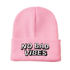 Pink knit beanie hat with embroidered NO BAD VIBES slogan and classic folded cuff
