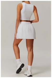 Side view of white ribbed sleeveless crop top and high-waisted pleated tennis skirt