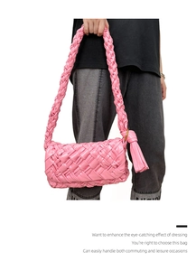 Detail of pink woven leather shoulder bag with decorative knot handle and tassels