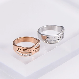Detail of rose gold and silver interlocking rings with Roman numerals and small crystals