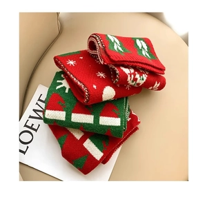 Close-up of knit Christmas scarf featuring woven snowflake and tree patterns