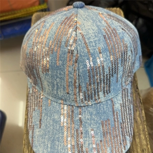 Detail of light blue denim baseball cap with rose gold sequins in a linear drip pattern
