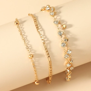 Detail view of gold-plated bracelet set with zircon stones, beads and Figaro chain