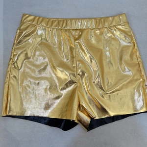 Détail du short doré métallisé avec taille élastique et revêtement texturé brillant
