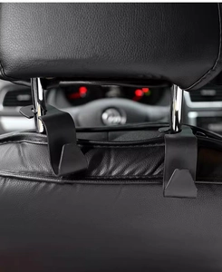 Close-up of matte black car headrest hooks installed on vehicle seat for storage