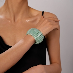 Vue détaillée du bracelet épais en acrylique vert translucide vintage sur un poignet