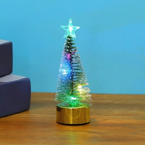 Mini LED Christmas tree with colorful lights and gold metal base on wooden desk