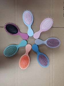 Top view of eight colorful portable mini air cushion hair brushes arranged in a circle