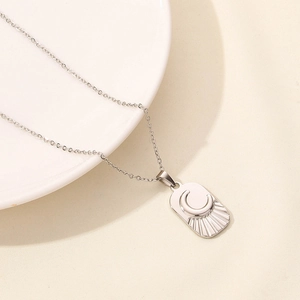 Detail macro view of silver moon and star rectangular pendant on thin chain necklace