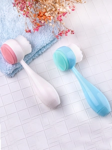 Close-up of double-sided facial brush with soft bristles and silicone massage pad