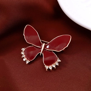 Close-up of vintage butterfly brooch with red enamel wings and sparkling rhinestones