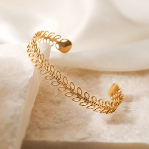 Elegant 18K gold plated stainless steel wheat ear open cuff bracelet on marble surface