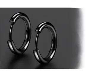 Macro shot of minimalist black titanium steel hoop earrings with polished matte finish