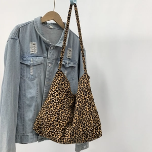 Close-up of leopard print corduroy tote bag showing texture and large shoulder strap