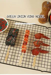 Detailed view of artificial green onion and chili rings on simulated food models