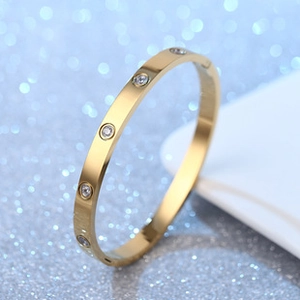 Macro detail of a luxury gold-plated bangle with sparkling circular inset crystals