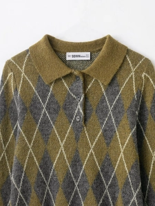 Detail eines Polo-Strickpullovers mit Rautenmuster in Senfgelb und Grau-Tönen