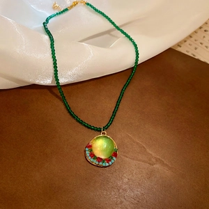 Vintage crystal beaded necklace with geometric round resin pendant and green gemstones