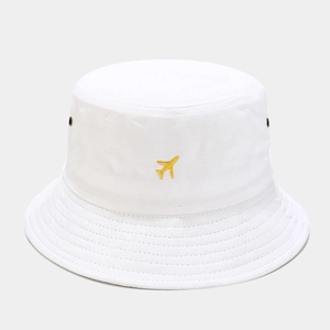 Détail d'un bob en coton blanc avec broderie avion jaune et œillets d'aération latéraux