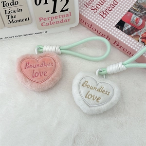 Detail of plush heart keychains in pink and white with Boundless Love embroidery
