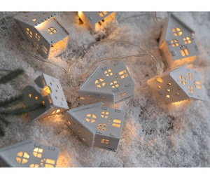 Close-up of mini white wooden LED house lights on faux snow for Christmas decor