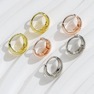 Detailed top view of C-shaped hoop earrings set in gold, rose gold, and silver finishes