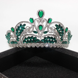 Detailed close-up of emerald green drop stones and zircon crystals on a silver bridal tiara